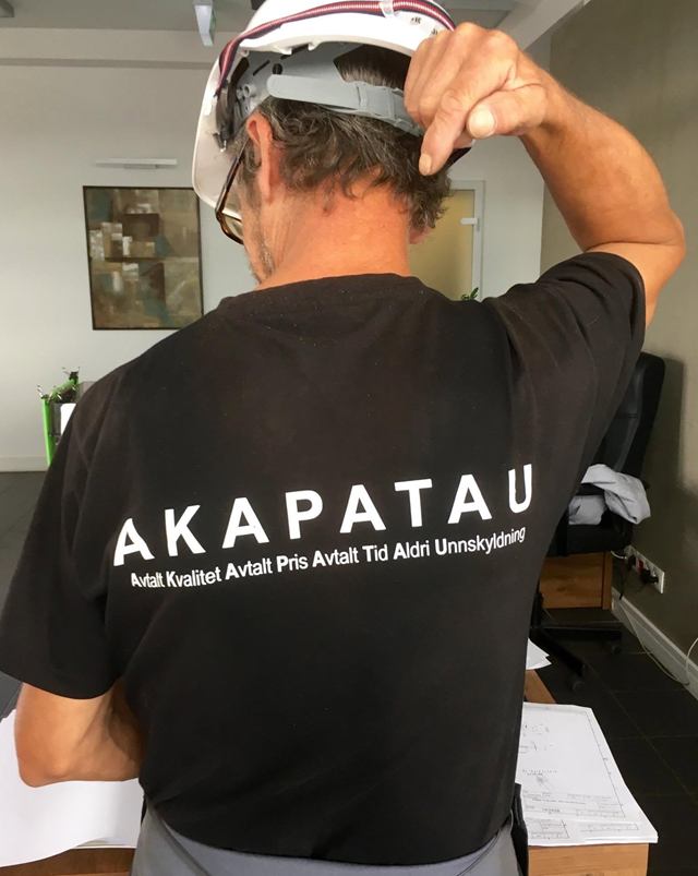 Ansatt med AKAPATAU trykket på arbeidsskjorta